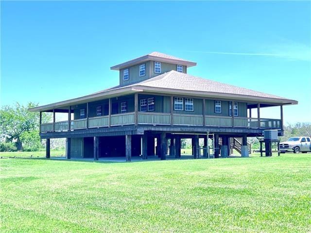 800 Anna St, Lafitte, LA 70067 - rear view of house featuring a lawn and a shingled roof