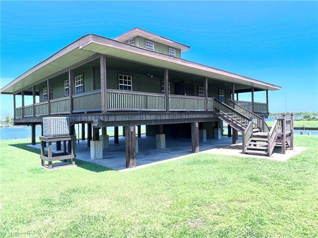 800 Anna St, Lafitte, LA 70067 - view of front facade with a front yard and stairs