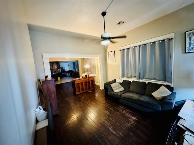 living room featuring ceiling fan and dark wood-type flooring