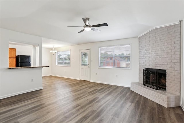 unfurnished living room with a fireplace, ceiling fan with notable chandelier, dark hardwood / wood-style floors, and lofted ceiling