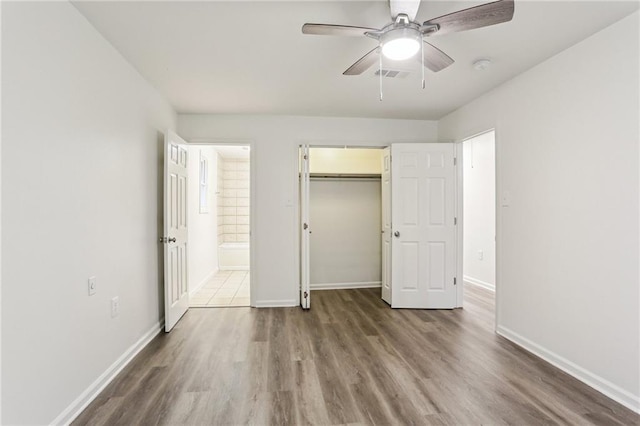 unfurnished bedroom featuring ceiling fan, dark wood-type flooring, and a closet