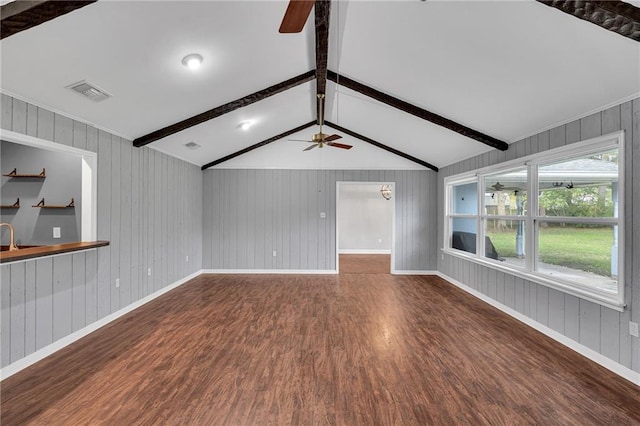 unfurnished living room featuring wooden walls, dark hardwood / wood-style flooring, ceiling fan, and lofted ceiling with beams