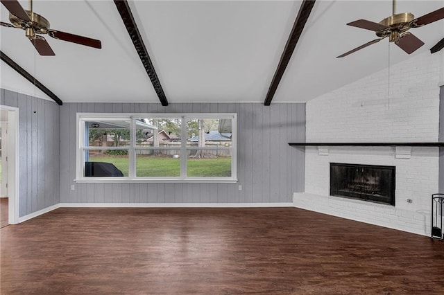 unfurnished living room featuring wood walls, a brick fireplace, vaulted ceiling with beams, dark hardwood / wood-style floors, and ceiling fan