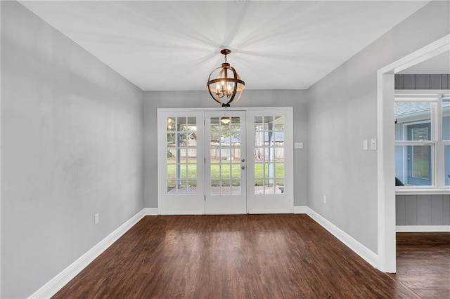 interior space featuring french doors, dark wood-type flooring, and a notable chandelier