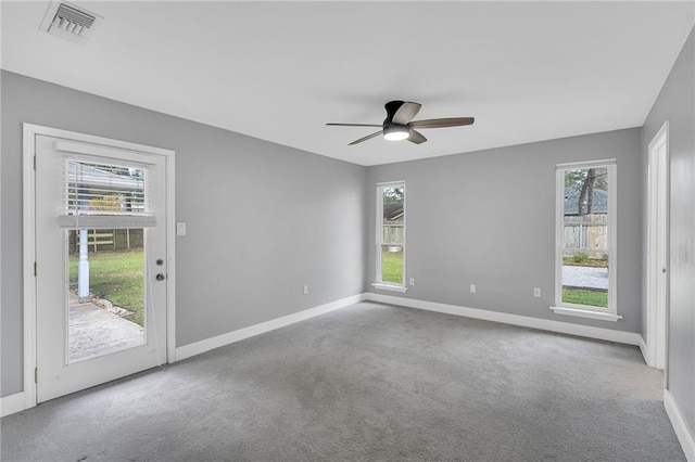 carpeted empty room with a wealth of natural light and ceiling fan