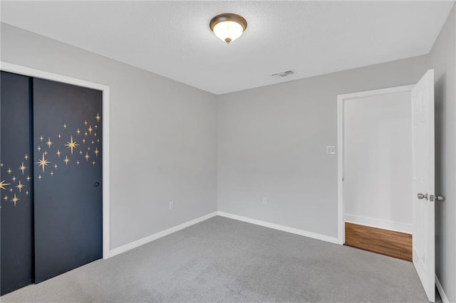 unfurnished bedroom featuring carpet flooring and a textured ceiling