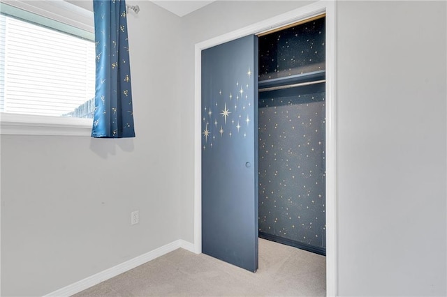 unfurnished bedroom featuring a closet and light colored carpet