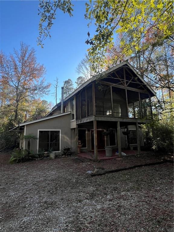 rear view of property featuring a sunroom