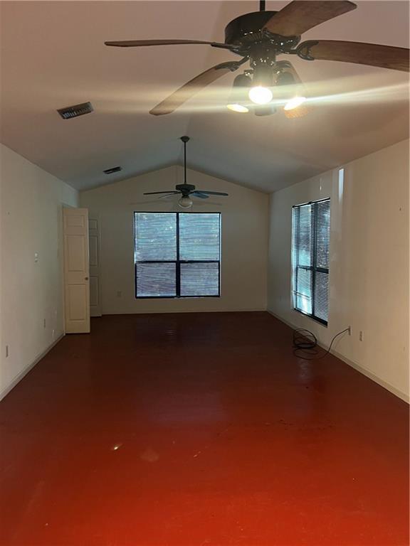 spare room featuring concrete flooring and vaulted ceiling