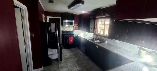 kitchen featuring black appliances, decorative backsplash, and sink