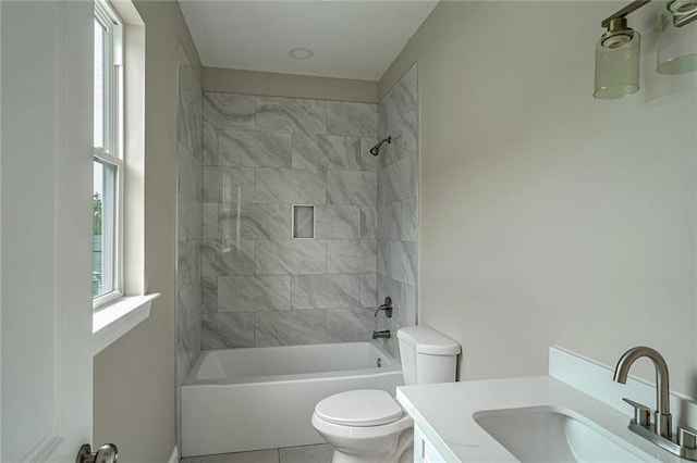 full bathroom featuring vanity, toilet, tiled shower / bath combo, and plenty of natural light