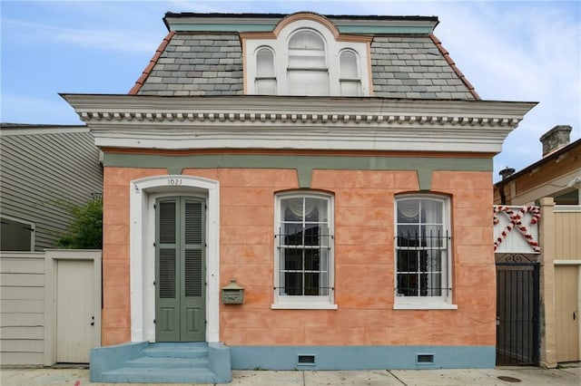 second empire-style home with crawl space, mansard roof, fence, and entry steps