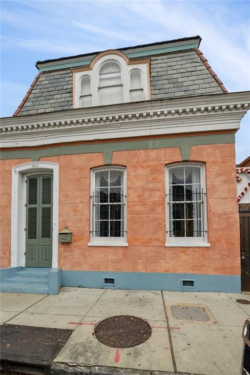 view of property exterior featuring a high end roof and mansard roof