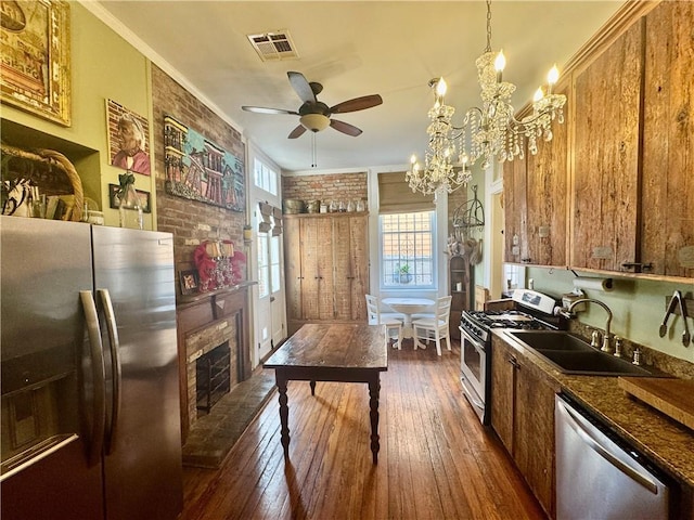 kitchen with crown molding, visible vents, dark wood-style flooring, and stainless steel appliances