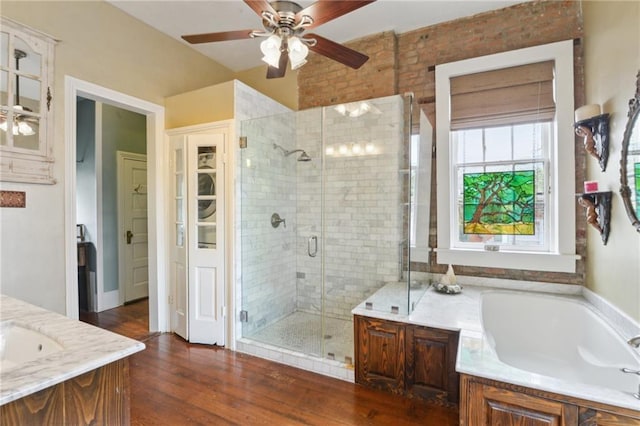 full bath featuring a ceiling fan, wood finished floors, a shower stall, a bath, and vanity