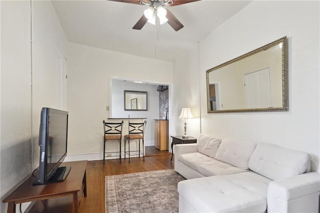 living area featuring a ceiling fan, wood finished floors, and baseboards