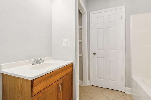 bathroom with tile patterned flooring, vanity, and a washtub