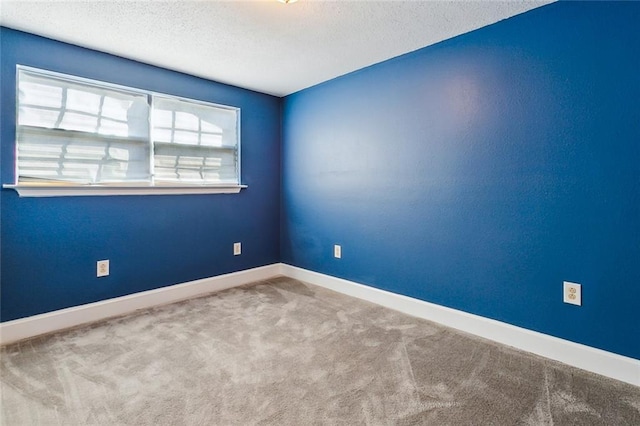 empty room with carpet floors and a textured ceiling