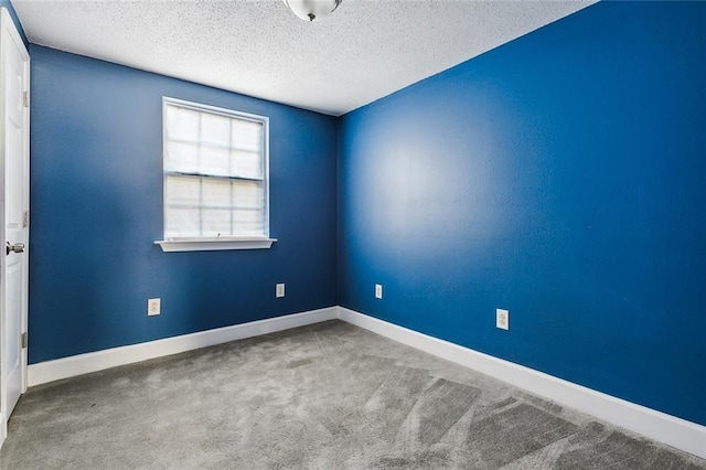 empty room featuring carpet flooring and a textured ceiling