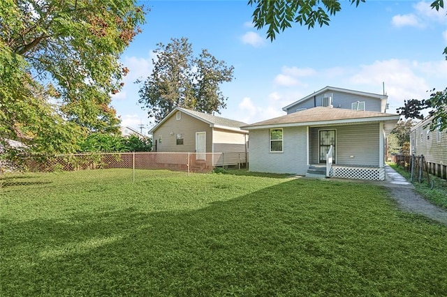 rear view of house featuring a yard