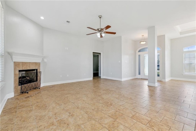 unfurnished living room with a tile fireplace and ceiling fan