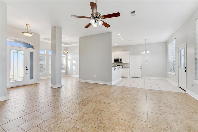 foyer with ceiling fan with notable chandelier