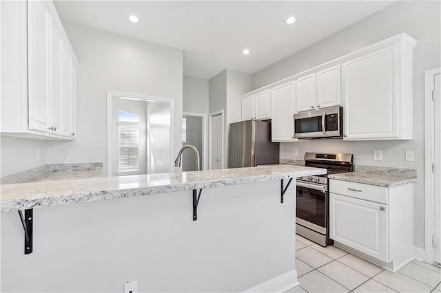 kitchen featuring white cabinets, a breakfast bar area, and appliances with stainless steel finishes