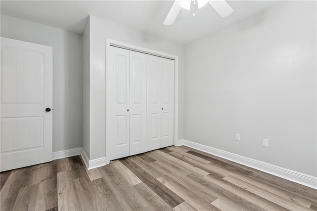 unfurnished bedroom featuring ceiling fan, a closet, and light hardwood / wood-style floors