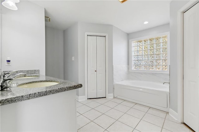 bathroom featuring tile patterned floors, a bathtub, and vanity