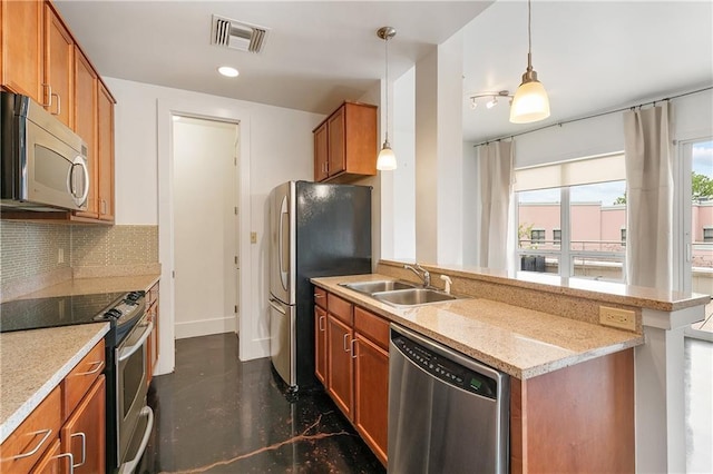 kitchen with pendant lighting, sink, backsplash, stainless steel appliances, and light stone counters