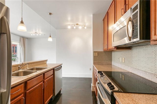 kitchen with appliances with stainless steel finishes, decorative light fixtures, sink, and decorative backsplash