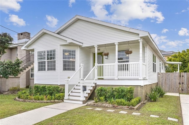 view of front of home with covered porch and a front lawn