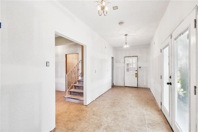 foyer featuring an inviting chandelier and stairway