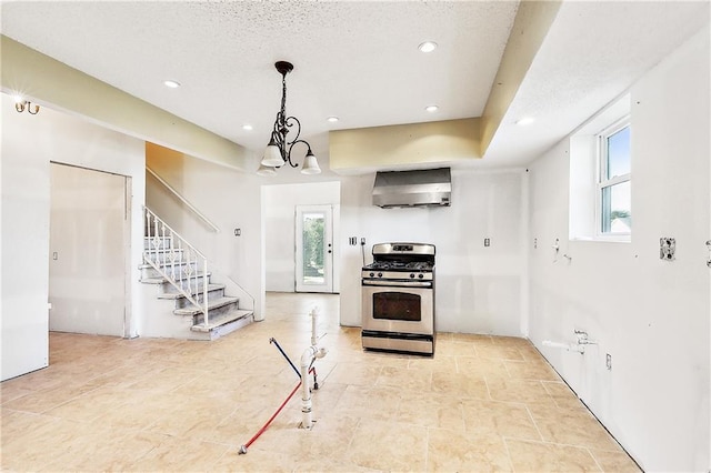 kitchen with wall chimney exhaust hood, stainless steel gas range oven, a wealth of natural light, and pendant lighting