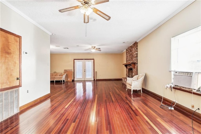 unfurnished room with visible vents, ornamental molding, wood finished floors, french doors, and a fireplace