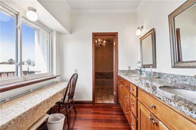 bathroom featuring crown molding, double vanity, a sink, and wood finished floors