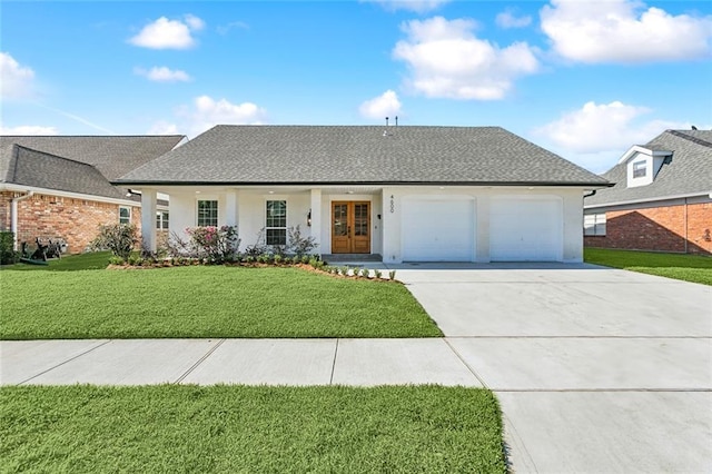 ranch-style home with a front lawn, a garage, and french doors