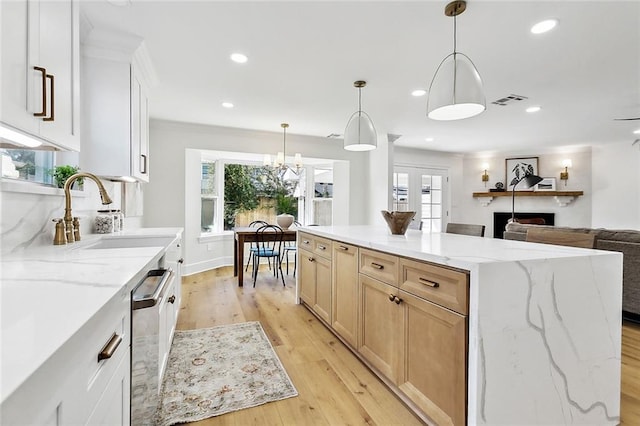 kitchen featuring a center island, white cabinets, a healthy amount of sunlight, and sink