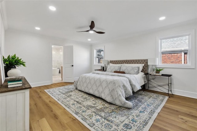 bedroom with hardwood / wood-style floors, ceiling fan, crown molding, and ensuite bath