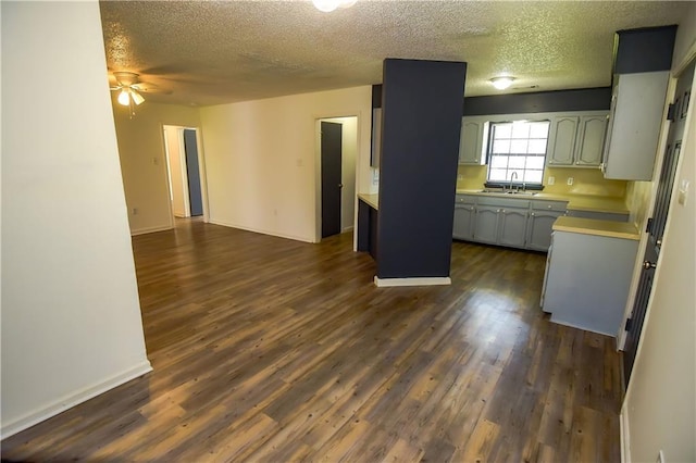 kitchen with ceiling fan, dark hardwood / wood-style flooring, and a textured ceiling