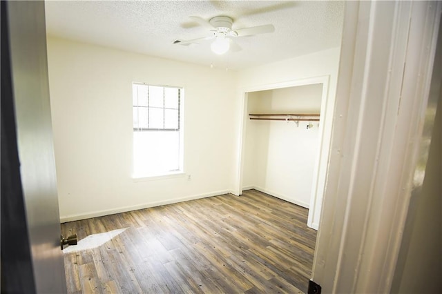 unfurnished bedroom with hardwood / wood-style floors, ceiling fan, a textured ceiling, and a closet