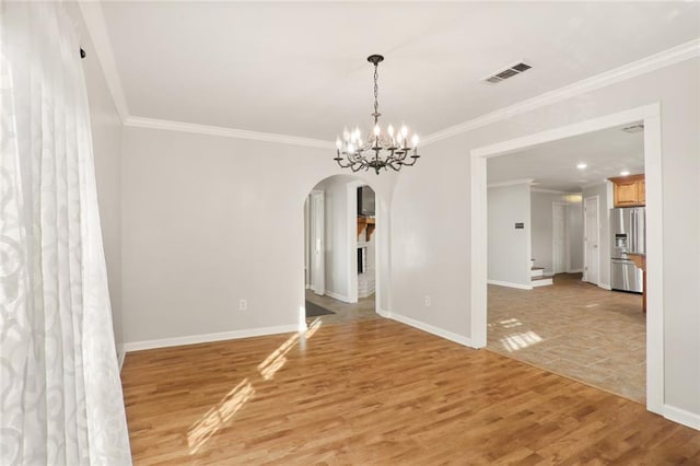 unfurnished room with hardwood / wood-style floors, an inviting chandelier, and ornamental molding