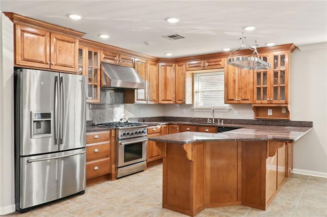 kitchen featuring dark stone counters, a kitchen breakfast bar, sink, kitchen peninsula, and stainless steel appliances