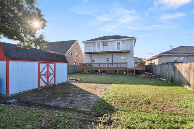 rear view of house featuring a patio, a deck, a storage shed, and a lawn