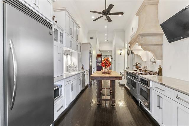 kitchen with built in appliances, ceiling fan, white cabinetry, and dark wood-type flooring