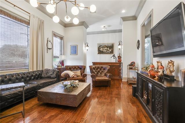 living room featuring dark hardwood / wood-style flooring, crown molding, and a notable chandelier