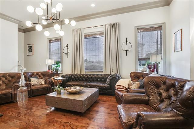 living room with a chandelier, crown molding, and dark wood-type flooring