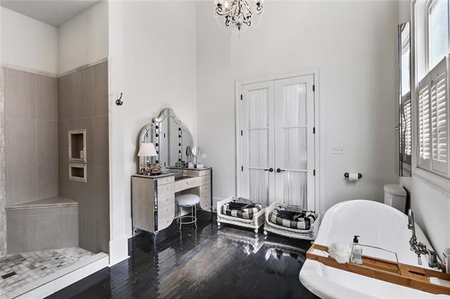 bathroom with a bathing tub, a chandelier, and wood-type flooring