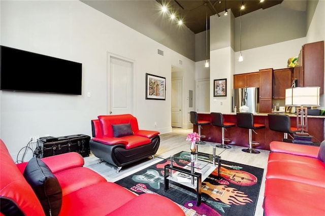 living room featuring a high ceiling and light hardwood / wood-style flooring