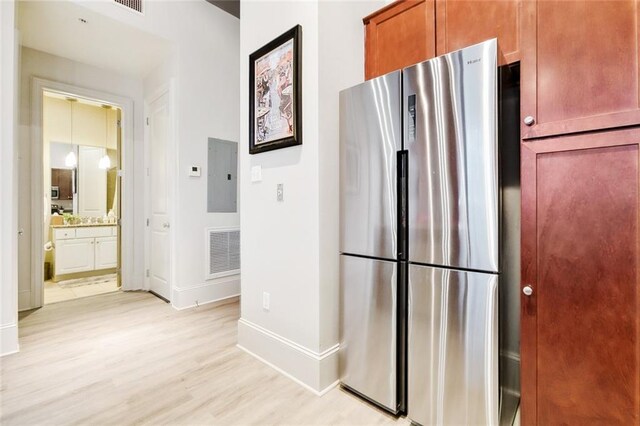 1201 Canal St Unit 271, New Orleans, LA 70112 - kitchen featuring freestanding refrigerator, electric panel, light wood-style flooring, and baseboards